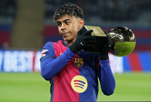 Best Football Academies in the World: Lamine Yamal, is seen presenting his Golden Boy trophy to Barcelona fans during a La Liga game.